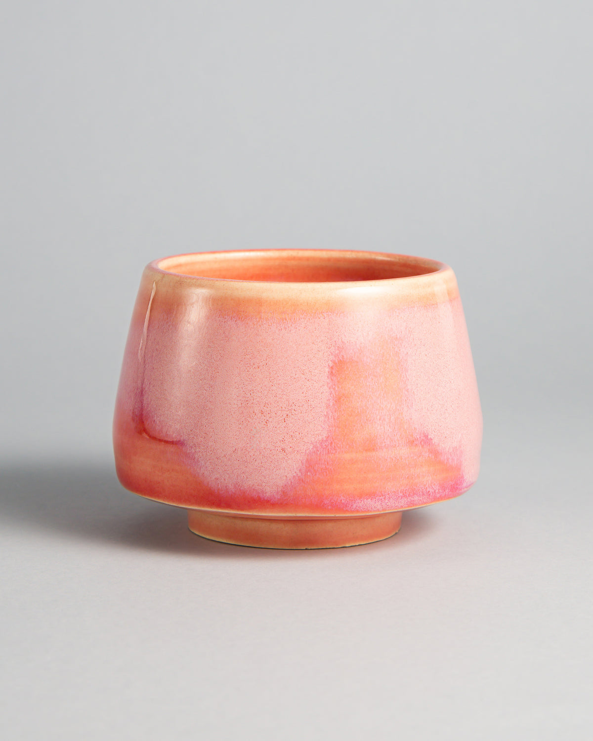 WINDY CUP 'PINK LADY', handmade stoneware cup without a handle by Studio 517. Glossy soft pink with pale, almost white clouds across the middle and a deeper rose blush near the foot, like the skin of a ripe apple.