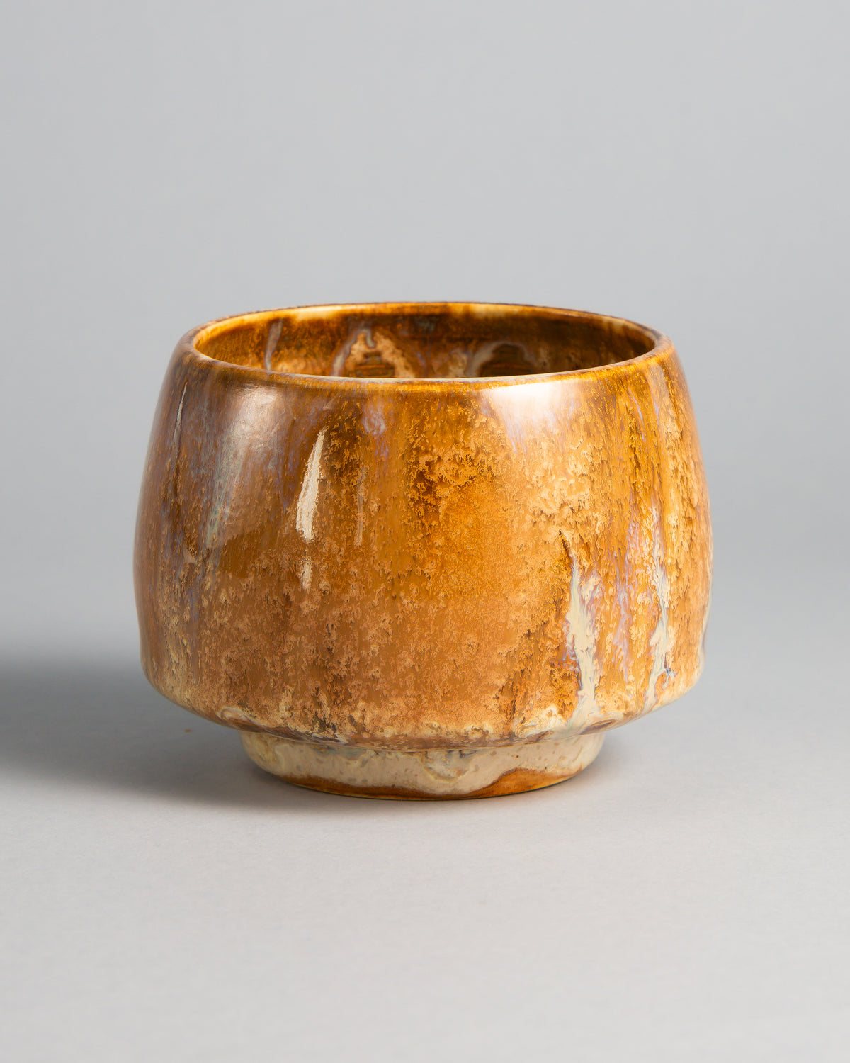 WINDY CUP 'SALTED CARAMEL', handmade stoneware cup without a handle by Studio 517. Glossy caramel and amber brown with darker streaks and thin cream drips running down the sides to a pale foot, warm like the first sip of a cortado.