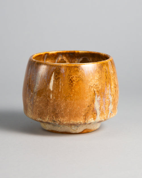 WINDY CUP 'SALTED CARAMEL', handmade stoneware cup without a handle by Studio 517. Glossy caramel and amber brown with darker streaks and thin cream drips running down the sides to a pale foot, warm like the first sip of a cortado.